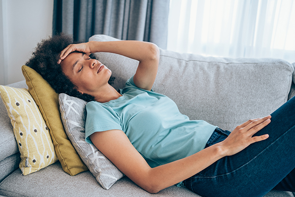 Woman lying on couch, feeling ill