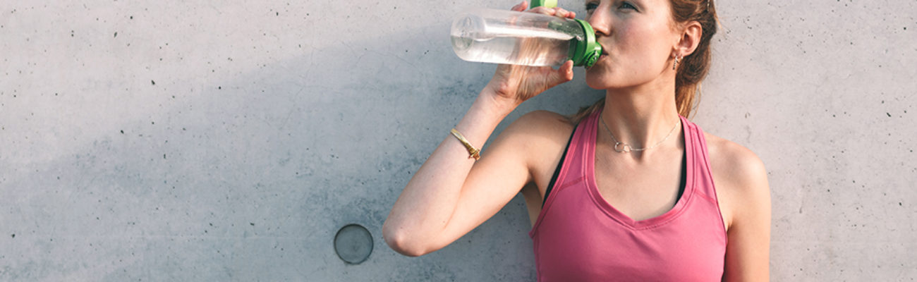 Woman drinking from reusable water bottle