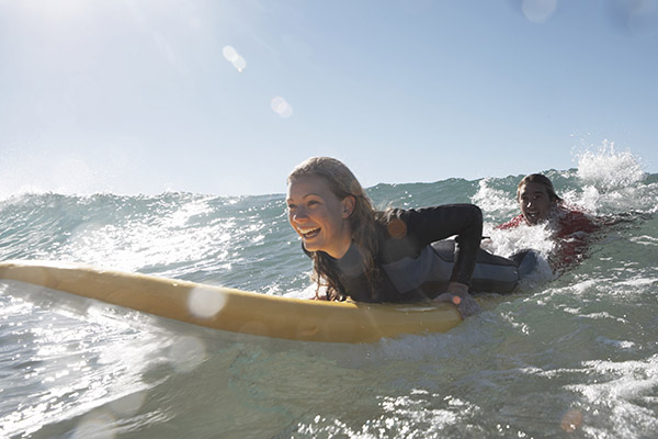 Woman taking surfing lesson