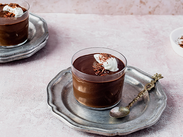 Chocolate Shakeology Pudding in a glass cup on silver tray