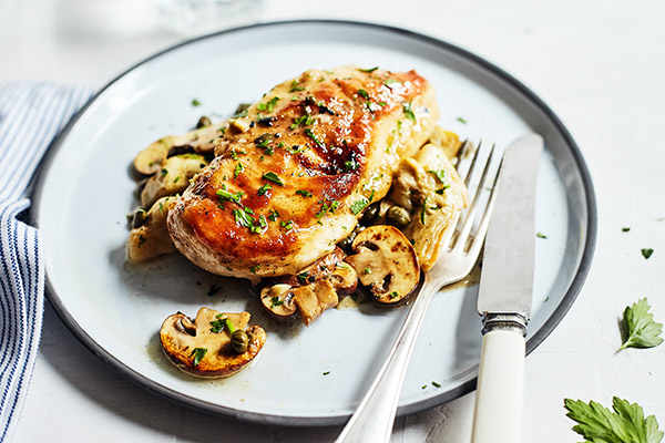 This healthier chicken piccata recipe is prepared in the classic style and topped with flavorful mushrooms, artichokes, and capers.