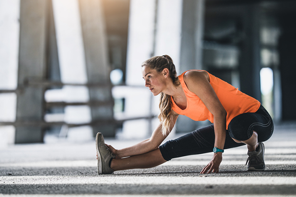 lunging leg stretch woman | heart rate elevated after workout