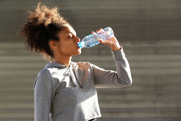 woman drinking water bottle | heart rate elevated after workout