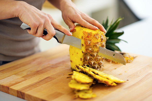 Woman cutting pineapple