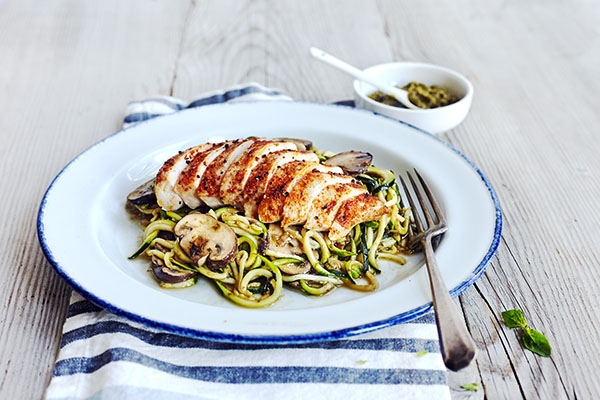 This savory Zucchini noodles recipe is topped with pesto, sautéed mushrooms, and chicken for an ultra-low in calorie, low-carb substitute for pasta.
