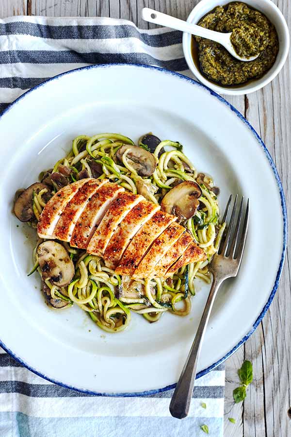 This savory Zucchini noodles recipe is topped with pesto, sautéed mushrooms, and chicken for an ultra-low in calorie, low-carb substitute for pasta.