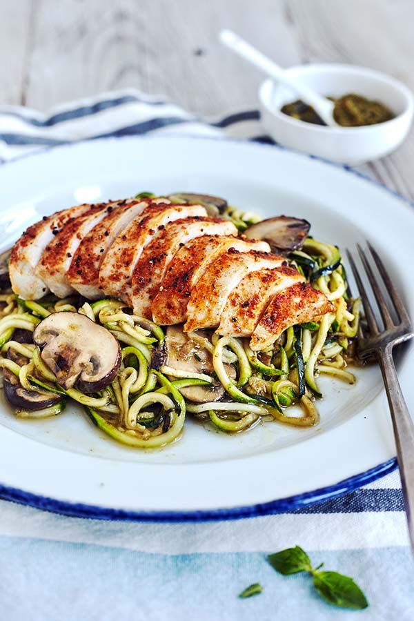 This savory Zucchini noodles recipe is topped with pesto, sautéed mushrooms, and chicken for an ultra-low in calorie, low-carb substitute for pasta.