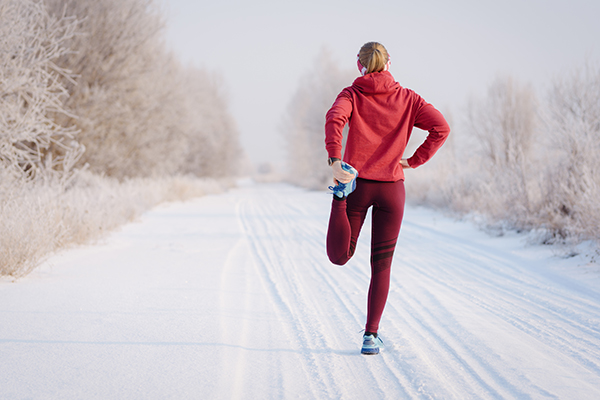 Woman tying shoe outside winter