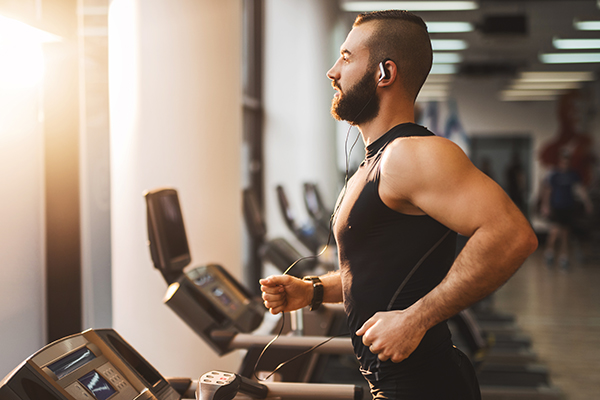 Muscular man running on treadmill