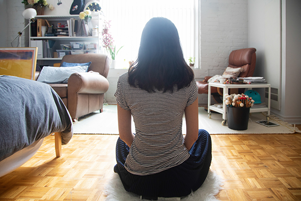 Woman meditating alone at home