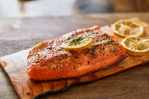 cooked cedar planked salmon with lemon and dill