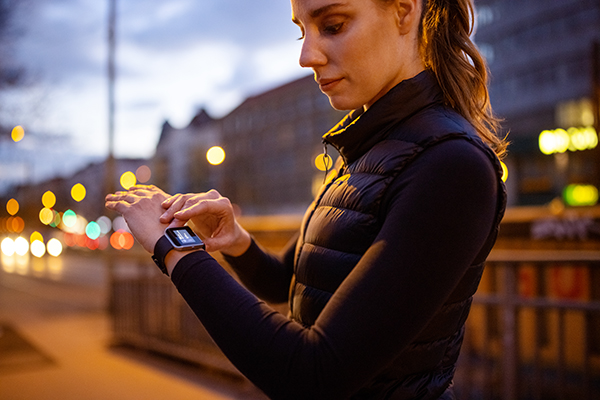Woman checking her smartwatch before night run