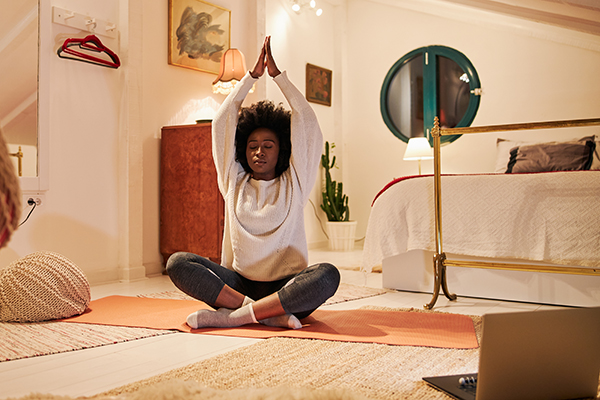 Woman doing yoga on bedroom floor before bed