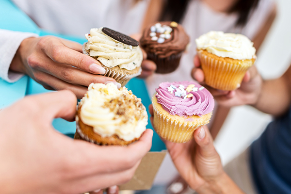 Close up of hands holding cupcakes