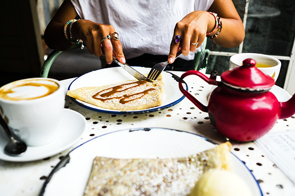 Close up of woman cutting into crepe