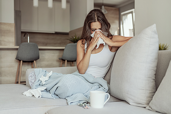 Sick woman blowing her nose