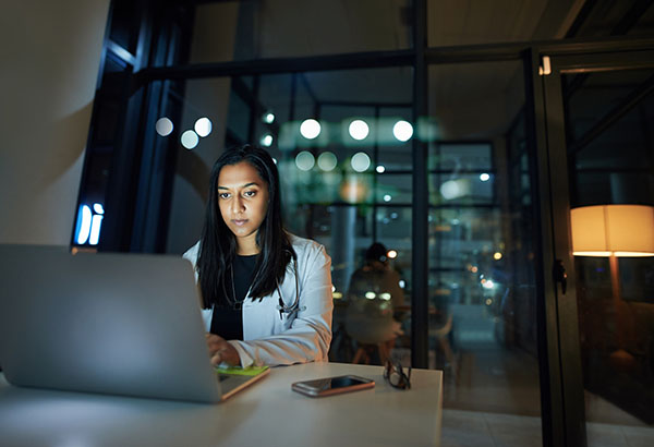 woman working on laptop late night | how to lose weight on the night shift