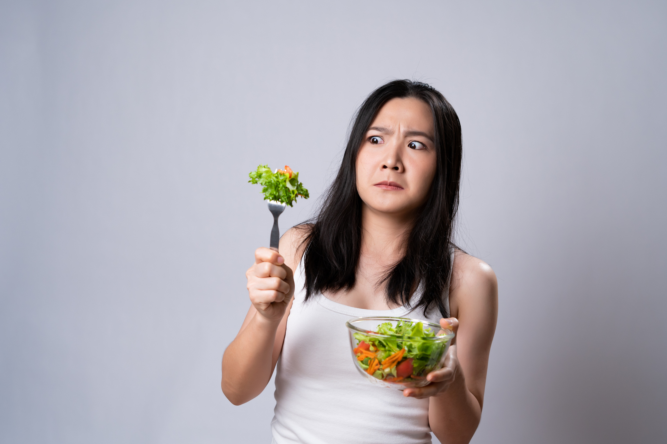 Woman Stares at Salad, disgusted | Obstacles to Losing Weight
