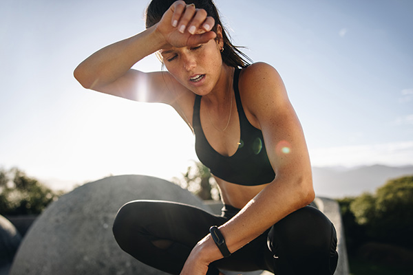 Female runner wiping sweat from face