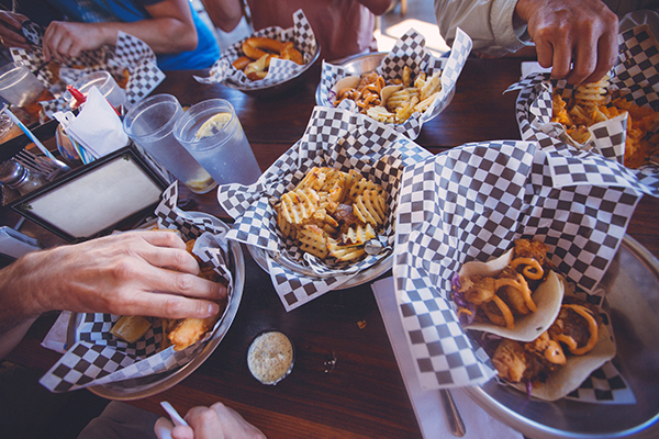 Friends eating french fries, greasy food