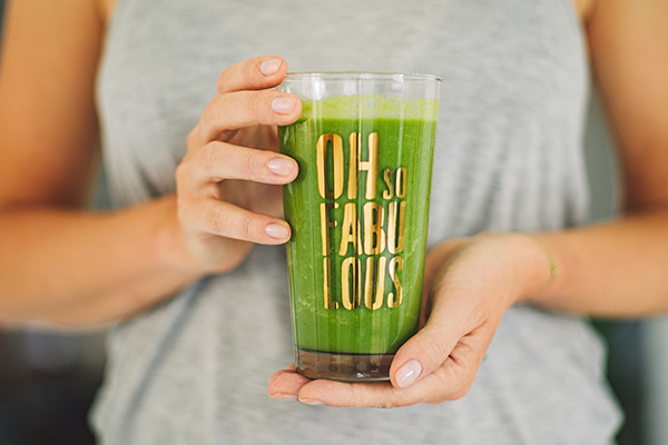 Woman holding green smoothie