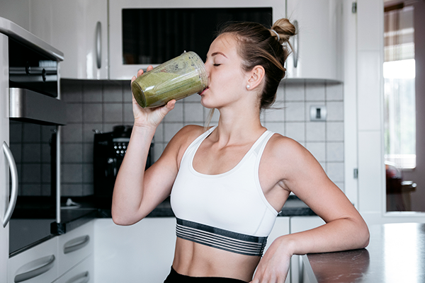 woman drinking protein shake | beginner workout tips