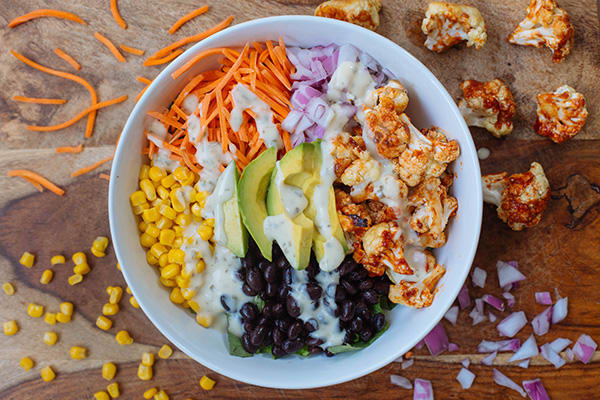 This barbecued cauliflower salad features smokey barbequed florets, black beans, corn kernels, ripe avocado, and a healthier ranch dressing.