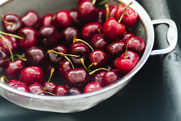 Strainer with cherries in a sink