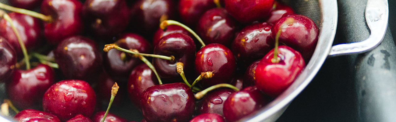 Strainer with cherries in a sink