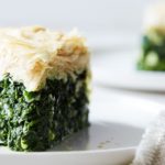 Our Spanikopita, or Greek Spinach pie, is a rich pastry stuffed with spinach and cheese. featuring healthier phyllo dough, onion, and crumbled feta.