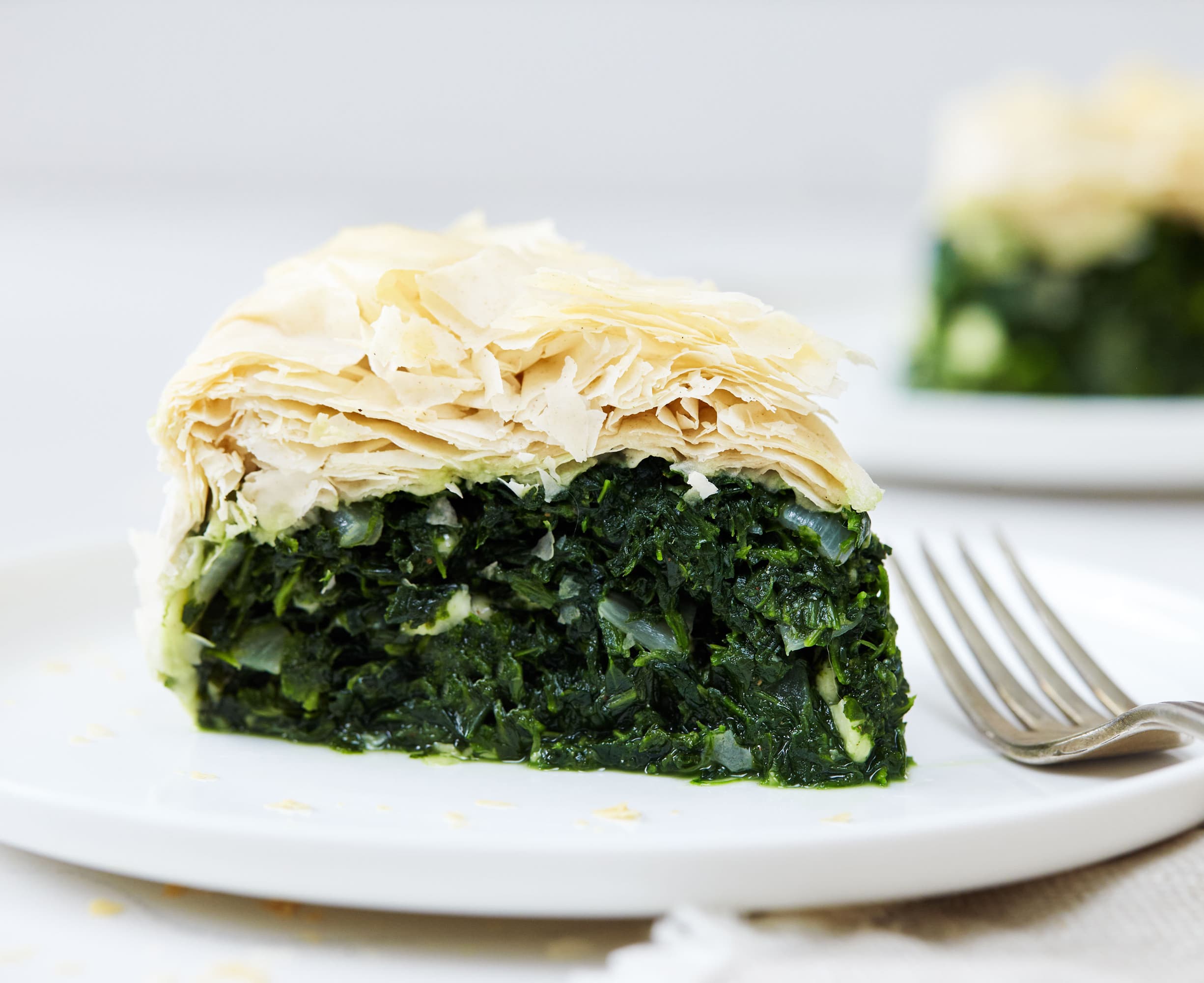 Our Spanikopita, or Greek Spinach pie, is a rich pastry stuffed with spinach and cheese. featuring healthier phyllo dough, onion, and crumbled feta.