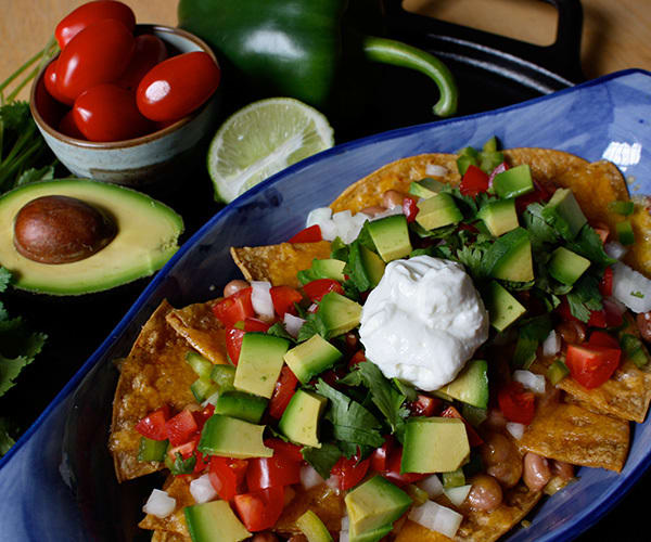 Healthy nachos with tomato, avocado, and cilantro