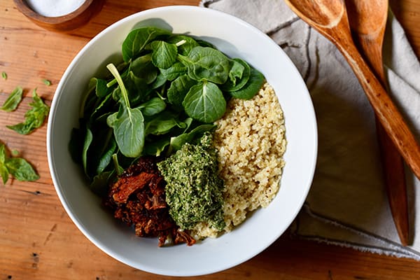 This Quinoa with Sun-Dried Tomatoes and Pesto recipe is a bowl of superfood that tastes incredible made with hemp seeds, fresh baby spinach, and basil.