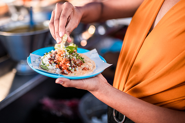 Women holding plate with a taco on it