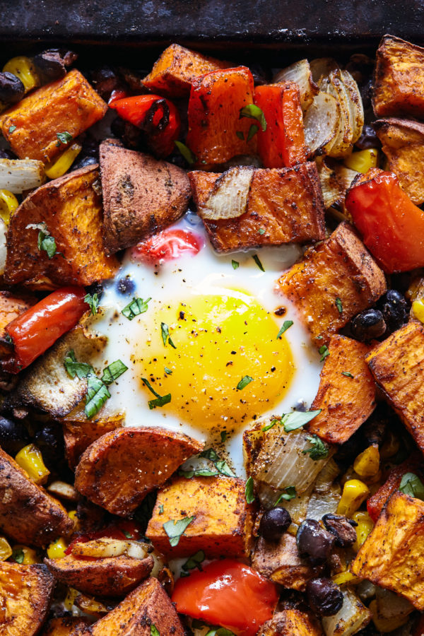 This fragrantly spiced Sweet Potato Hash recipe features oven-baked eggs, cumin, smoked paprika, and is topped with fresh cilantro.