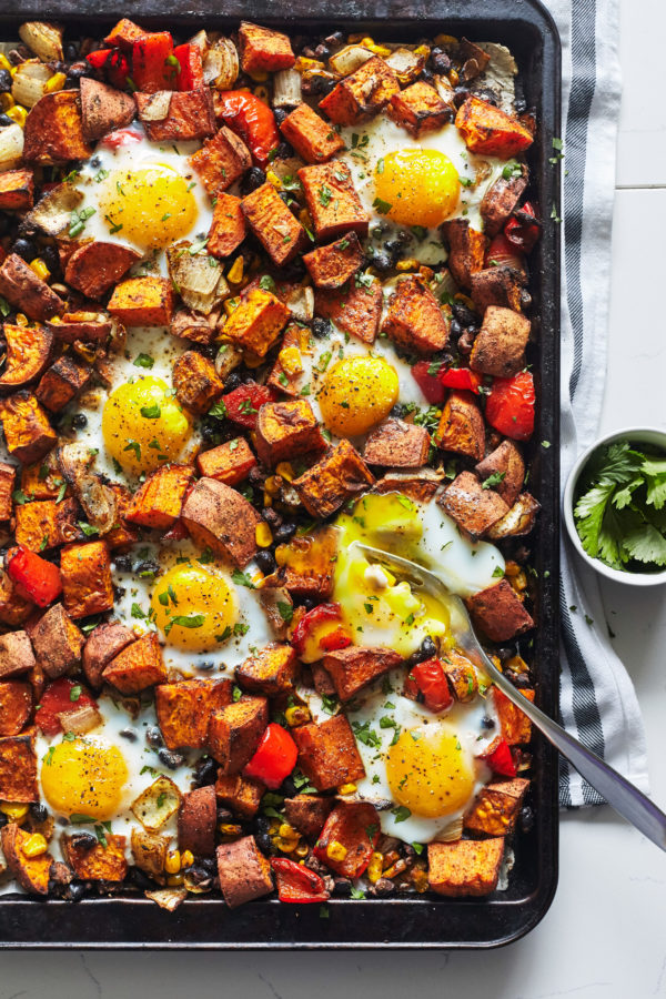 This fragrantly spiced Sweet Potato Hash recipe features oven-baked eggs, cumin, smoked paprika, and is topped with fresh cilantro.