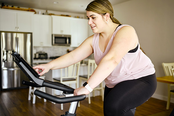 Woman using exercise bike at home