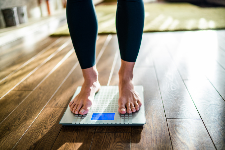 woman weighing herself | Maintain Ideal Body Weight