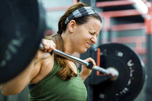 Young woman lifting weights in gym