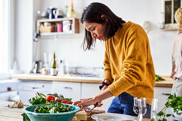 Woman cutting vegetables in kitchen