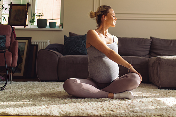 Pregnant woman doing yoga at home.