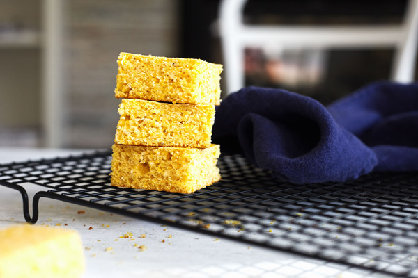 Classic cornbread fresh from the oven, sliced and stacked on a cooling rack.