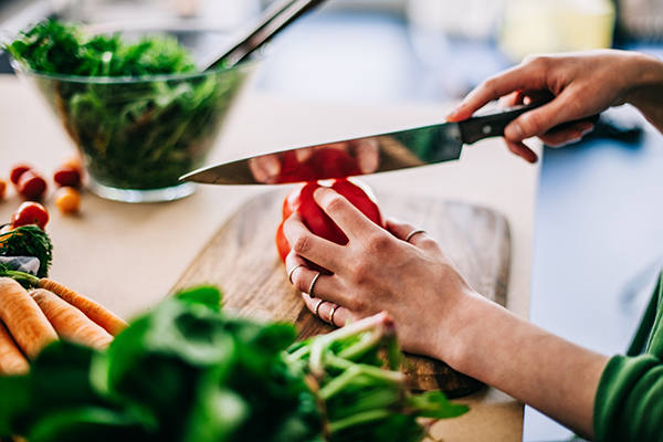 Woman chopping vegetables for a vegetarian salad