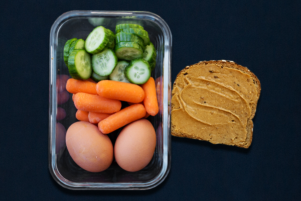 Pre-workout meal for 80 Day Obsession with hard-boiled eggs, cucumber slices, baby carrots and peanut butter toast.