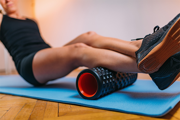 woman foam rolling calves | sore calves