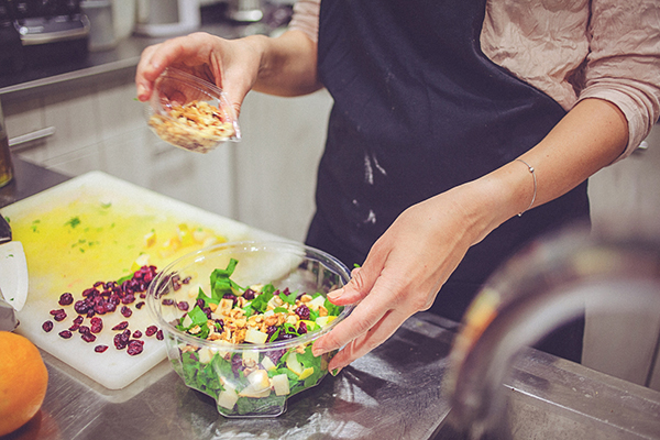 Woman adding toppings to a salad