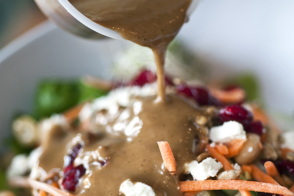 Pouring dressing on a salad