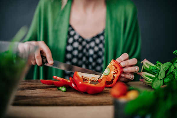 Woman chopping red bell peppers