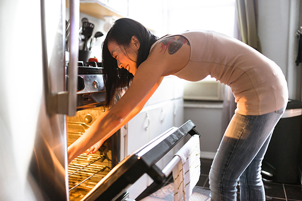 Woman putting food in oven