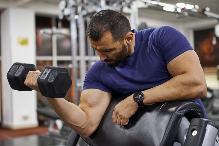 man doing one arm preacher curl | Preacher Curl